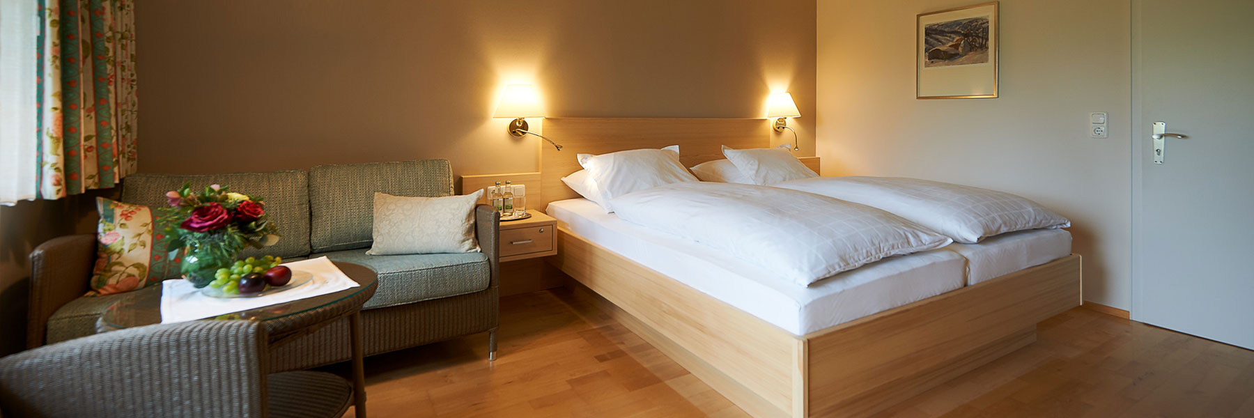 Gemütlicher Schlafbereich mit Doppelbett im Zimmer unserer Pension in Oberstaufen